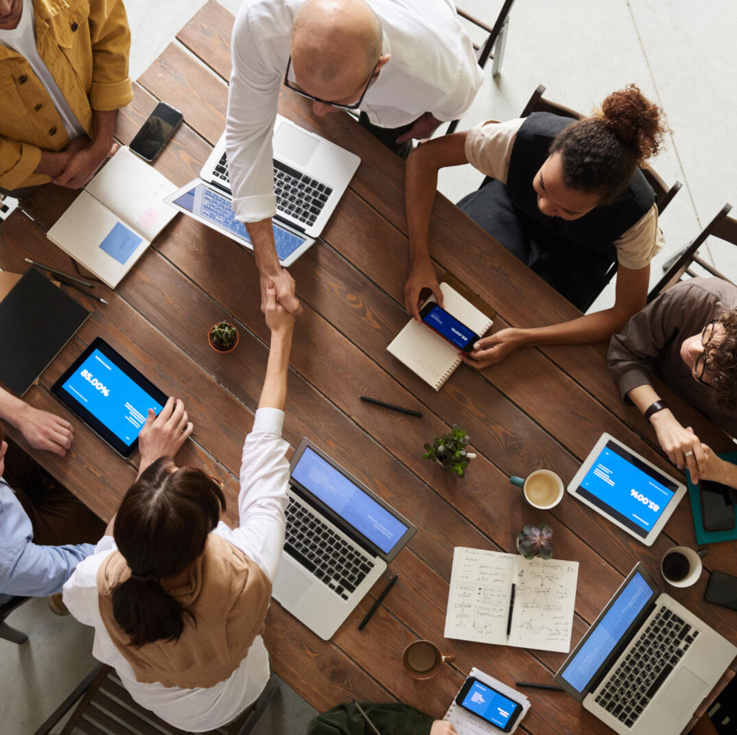 Picture of people working around a desk in a collaborative manner